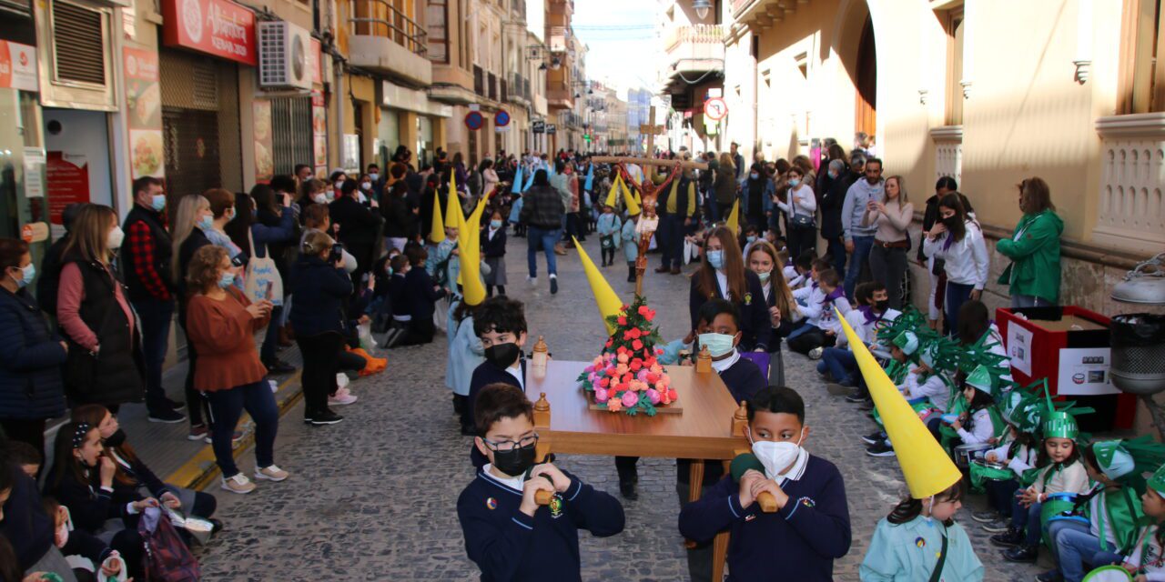 La procesión infantil de los alumnos del colegio Santa Ana llena la calle principal de capuruchos y caramelos