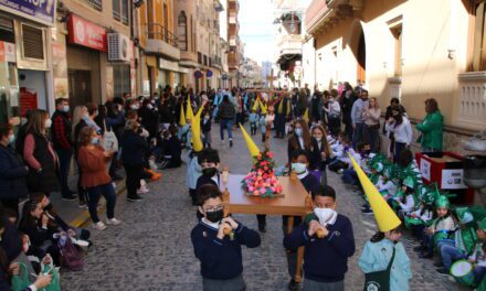 La procesión infantil de los alumnos del colegio Santa Ana llena la calle principal de capuruchos y caramelos