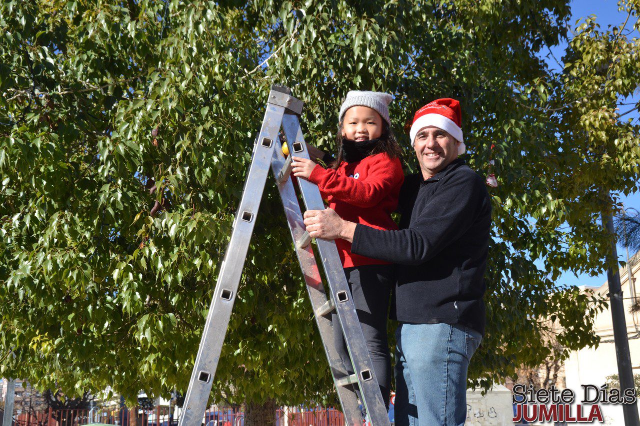 Los vecinos y niños de San Fermín decoran el árbol de Navidad