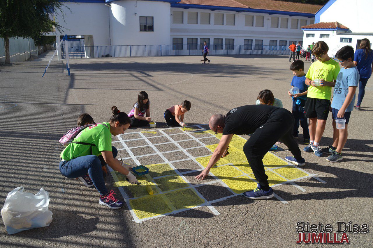 Alumnos, padres y madres y profesores del colegio Miguel Hernández dan color al centro, pintando juegos en el patio